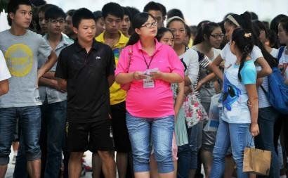 6月7日,雅安天全中学的吕莎莎老师(中)在考场外等待自己的学生出来。