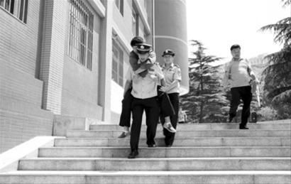 　　在解放路小学考点执勤的梁坤发现一考生拄着双拐吃力地走出考场，他背起该考生将其送出考场。摄影记者朴峰