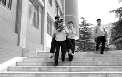 　　在解放路小学考点执勤的梁坤发现一考生拄着双拐吃力地走出考场，他背起该考生将其送出考场。摄影记者朴峰